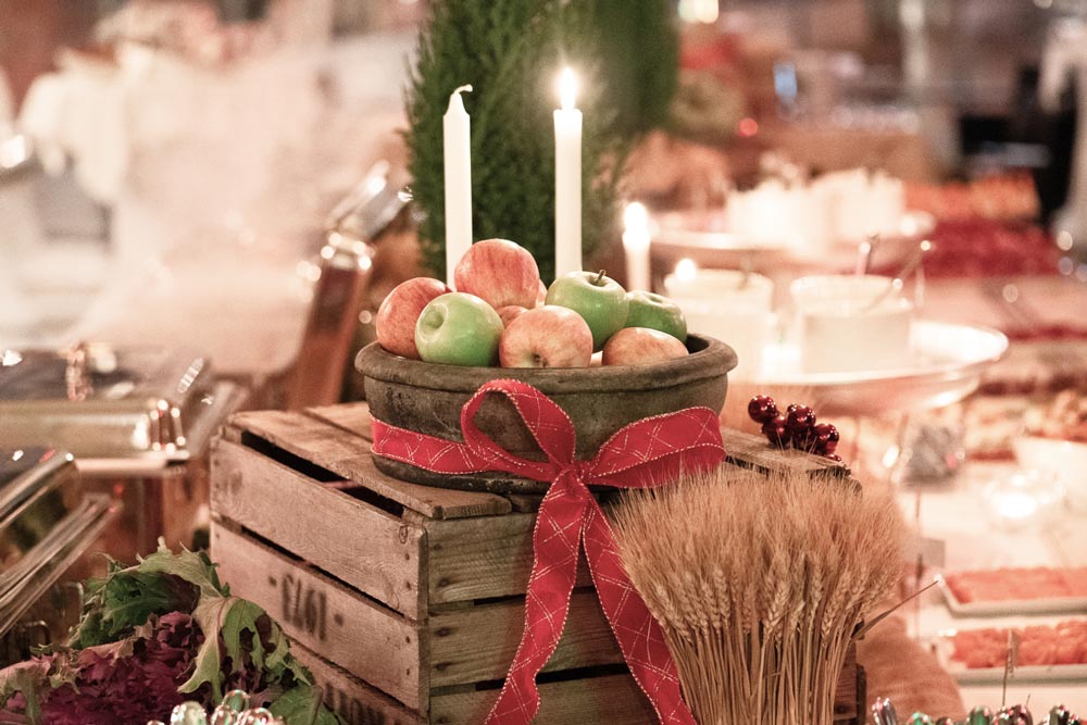 Julat och en korg äpplen uppdukat tillsammans med juldekorationer