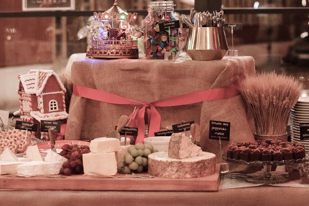 Ostar, pepparkakshus och andra juldesserter uppdukat på ett bord